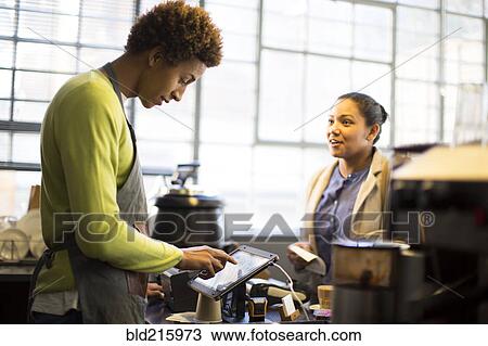 Mixed race barista assisting customer in coffee shop View Large Photo Image Stock Image - Mixed race barista assisting customer in coffee shop. Fotosearch