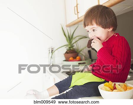 Mixed race boy eating brownie View Large Photo Image Stock Photo - Mixed race boy eating brownie. Fotosearch
