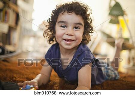 Stock Photo - Mixed race boy laying on floor. Fotosearch