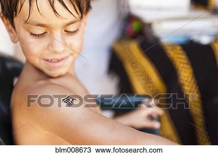 Mixed race boy looking at temporary tattoo View Large Photo Image Stock Image - Mixed race boy looking at temporary tattoo. Fotosearch