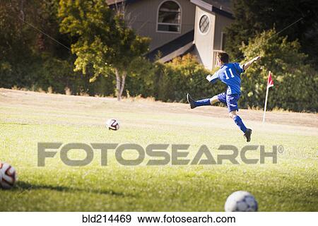 Mixed race boy playing soccer on field View Large Photo Image Stock Photo - Mixed race boy playing soccer on field. Fotosearch