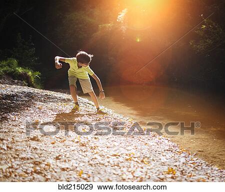Mixed race boy skipping stones in stream View Large Photo Image Stock Photo - Mixed race boy skipping stones in stream. Fotosearch
