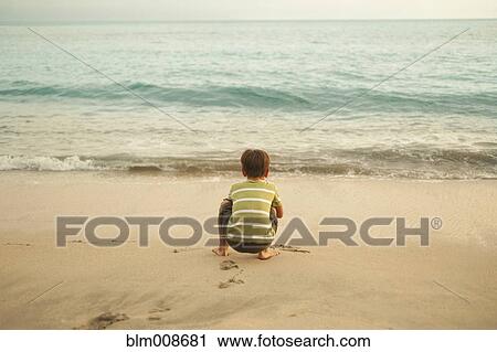 Mixed race boy squatting on beach playing View Large Photo Image Stock Image - Mixed race boy squatting on beach playing. Fotosearch