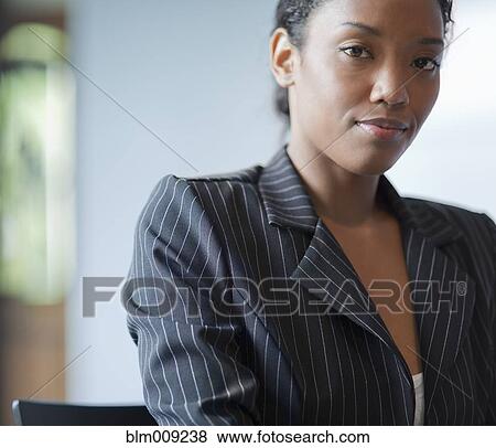 Mixed race businesswoman sitting at desk View Large Photo Image Stock Photo - Mixed race businesswoman sitting at desk. Fotosearch