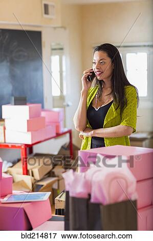 Stock Photo - Mixed race businesswoman talking on telephone in office. Fotosearch