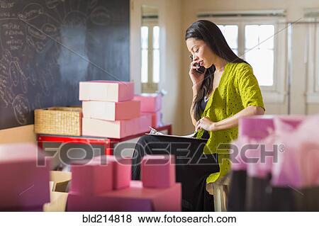 Mixed race businesswoman talking on telephone in office View Large Photo Image Stock Photo - Mixed race businesswoman talking on telephone in office. Fotosearch