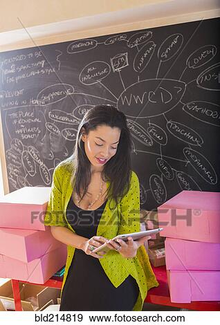 Mixed race businesswoman using digital tablet in office View Large Photo Image Stock Photo - Mixed race businesswoman using digital tablet in office. Fotosearch