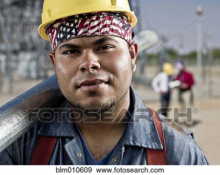 Mixed race construction worker carrying pipe View Large Photo Image Stock Photo - Mixed race construction worker carrying pipe. Fotosearch