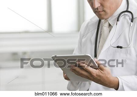 Mixed race doctor using digital tablet View Large Photo Image Stock Photograph - Mixed race doctor using digital tablet. Fotosearch