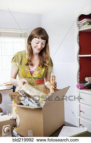 Mixed race dressmaker unpacking box at sewing table View Large Photo Image Stock Image - Mixed race dressmaker unpacking box at sewing table. Fotosearch