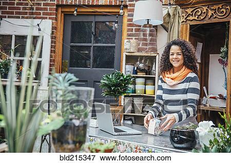 Mixed race employee using laptop in plant nursery View Large Photo Image Stock Photo - Mixed race employee using laptop in plant nursery. Fotosearch