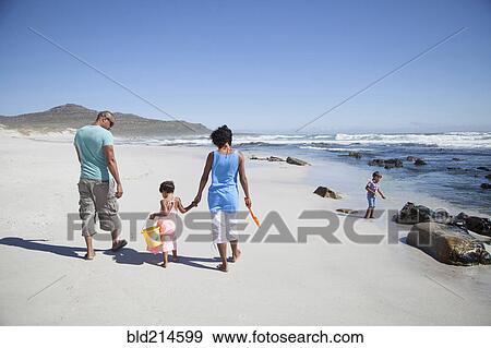 Mixed race family walking on beach View Large Photo Image Stock Photo - Mixed race family walking on beach. Fotosearch