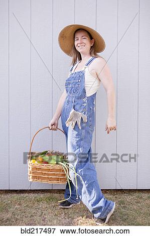 Mixed race farmer holding basket of vegetables View Large Photo Image Stock Photo - Mixed race farmer holding basket of vegetables. Fotosearch