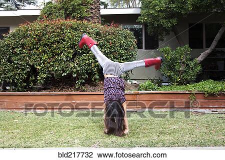 Mixed race girl doing cartwheels in backyard View Large Photo Image Stock Image - Mixed race girl doing cartwheels in backyard. Fotosearch