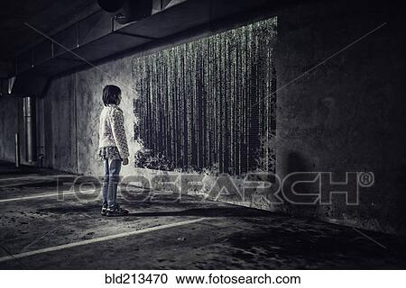 Stock Image - Mixed race girl examining binary code on screen in parking lot. Fotosearch