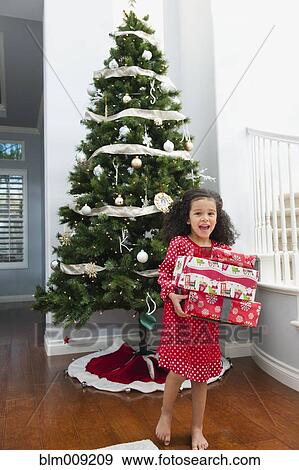 Mixed race girl holding Christmas gift View Large Photo Image Stock Photo - Mixed race girl holding Christmas gift. Fotosearch