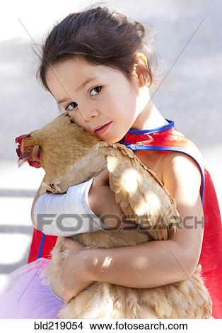 Picture - Mixed race girl hugging chicken. Fotosearch