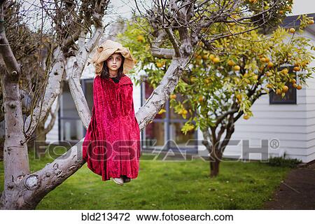 Mixed race girl in witch costume sitting in tree View Large Photo Image Stock Image - Mixed race girl in witch costume sitting in tree. Fotosearch
