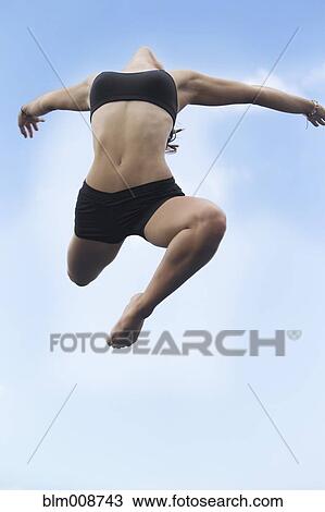 Stock Image - Mixed race girl jumping in air. Fotosearch