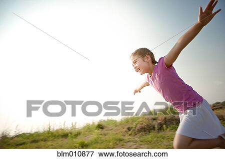 Stock Photo - Mixed race girl running outdoors. Fotosearch