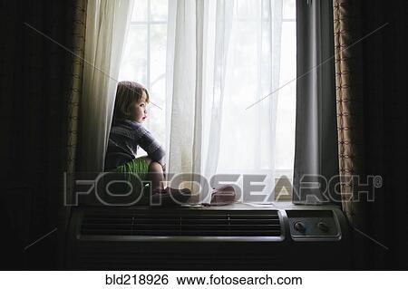Stock Photograph - Mixed race girl sitting in window. Fotosearch