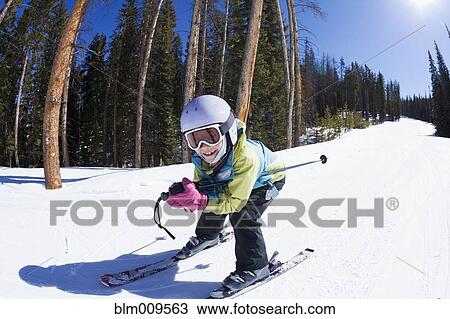 Stock Image - Mixed race girl skiing downhill. Fotosearch