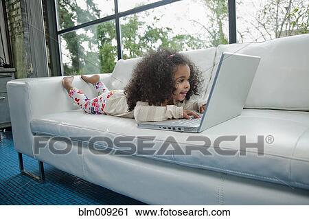 Mixed race girl using laptop on sofa View Large Photo Image Stock Image - Mixed race girl using laptop on sofa. Fotosearch