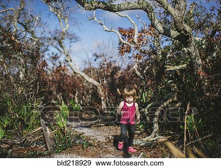 Stock Photo - Mixed race girl walking on dirt path. Fotosearch