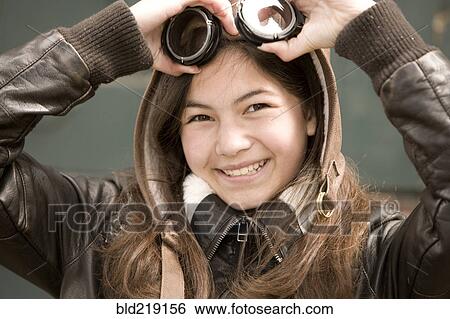 Stock Photograph - Mixed race girl wearing aviator goggles. Fotosearch