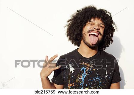 Mixed race man making a face and rock-on hand gesture View Large Photo Image Stock Photo - Mixed race man making a face and rock-on hand gesture. Fotosearch