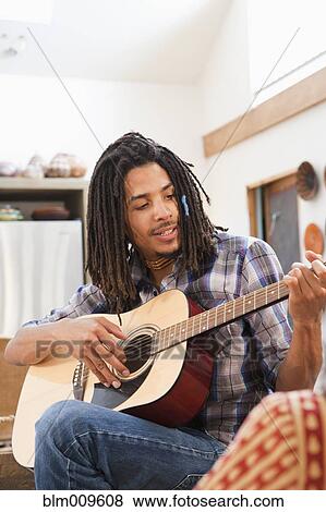 Stock Photo - Mixed race man playing guitar. Fotosearch