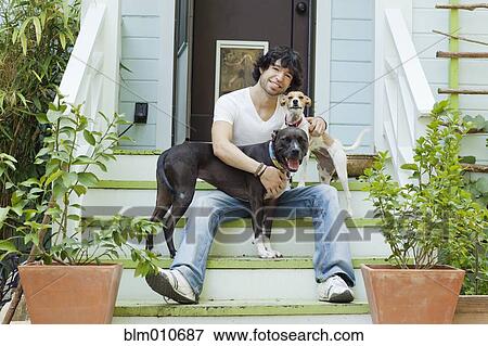 Mixed race man sitting on front stoop with dogs View Large Photo Image Stock Photo - Mixed race man sitting on front stoop with dogs. Fotosearch