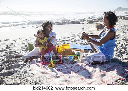 Mixed race mother photographing grandmother and daughter at beach View Large Photo Image Stock Image - Mixed race mother photographing grandmother and daughter at beach. Fotosearch