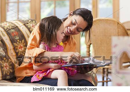 Mixed race mother reading book to daughter View Large Photo Image Stock Photo - Mixed race mother reading book to daughter. Fotosearch