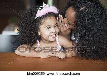 Mixed race mother whispering to daughter View Large Photo Image Stock Photo - Mixed race mother whispering to daughter. Fotosearch