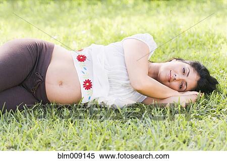 Mixed race pregnant woman laying in grass View Large Photo Image Stock Photography - Mixed race pregnant woman laying in grass. Fotosearch