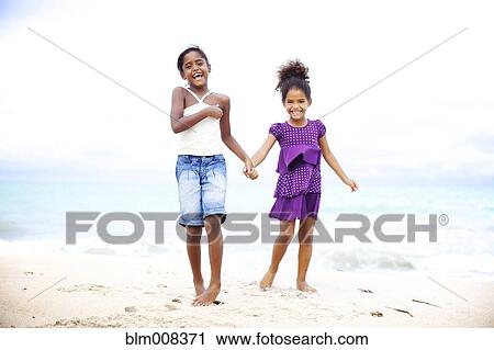 Mixed race sisters holding hands on beach View Large Photo Image Stock Image - Mixed race sisters holding hands on beach. Fotosearch