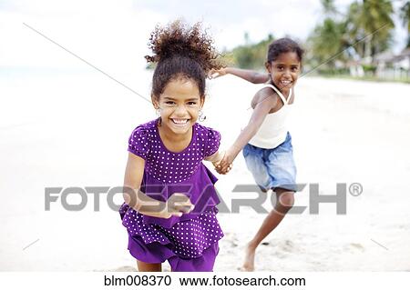 Mixed race sisters holding hands running on beach View Large Photo Image Stock Image - Mixed race sisters holding hands running on beach. Fotosearch