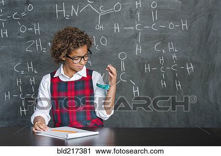 Stock Image - Mixed race student doing experiment in science class. Fotosearch
