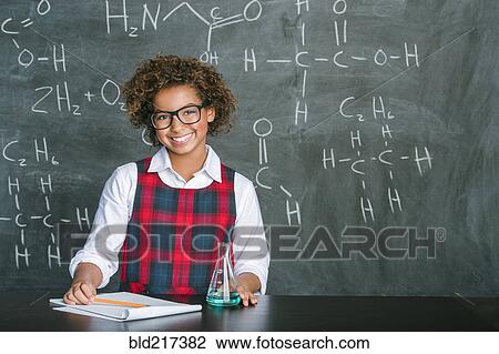 Stock Image - Mixed race student doing experiment in science class. Fotosearch