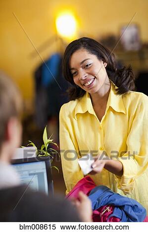 Mixed race woman handing cashier her credit card in store View Large Photo Image Stock Photography - Mixed race woman handing cashier her credit card in store. Fotosearch