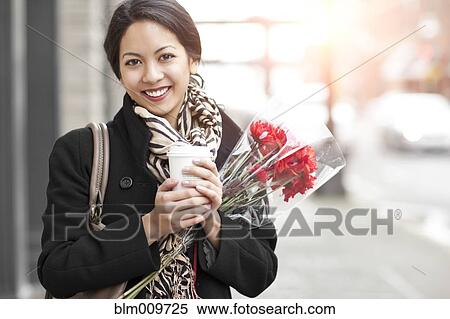Mixed race woman holding coffee and bouquet of flowers View Large Photo Image Stock Photography - Mixed race woman holding coffee and bouquet of flowers. Fotosearch