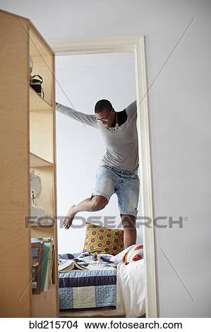 Mixed race woman jumping on bed View Large Photo Image Picture - Mixed race woman jumping on bed. Fotosearch