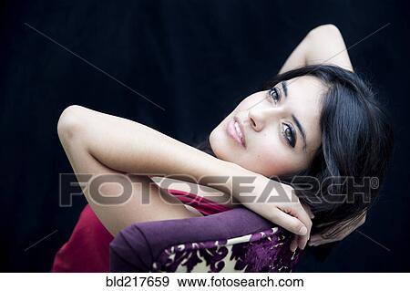 Mixed race woman leaning on armchair View Large Photo Image Stock Photo - Mixed race woman leaning on armchair. Fotosearch