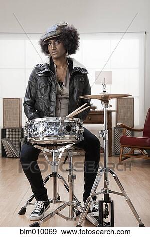 Stock Photo - Mixed race woman playing drums. Fotosearch