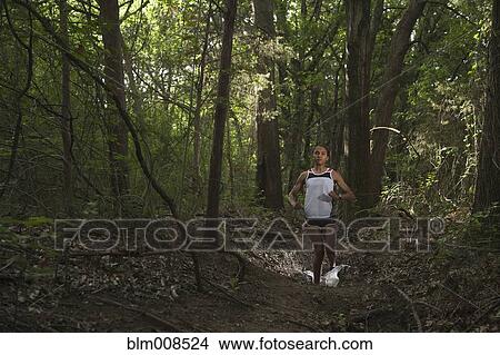 Mixed race woman running through forest View Large Photo Image Picture - Mixed race woman running through forest. Fotosearch