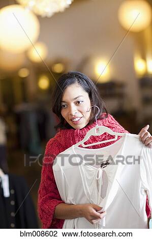 Mixed race woman shopping for shirt in store View Large Photo Image Stock Image - Mixed race woman shopping for shirt in store. Fotosearch