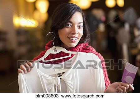 Mixed race woman shopping for shirt in store View Large Photo Image Stock Image - Mixed race woman shopping for shirt in store. Fotosearch
