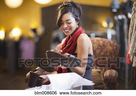 Mixed race woman shopping for shoes in store View Large Photo Image Stock Photograph - Mixed race woman shopping for shoes in store. Fotosearch