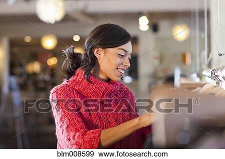 Mixed race woman shopping in store View Large Photo Image Stock Photo - Mixed race woman shopping in store. Fotosearch